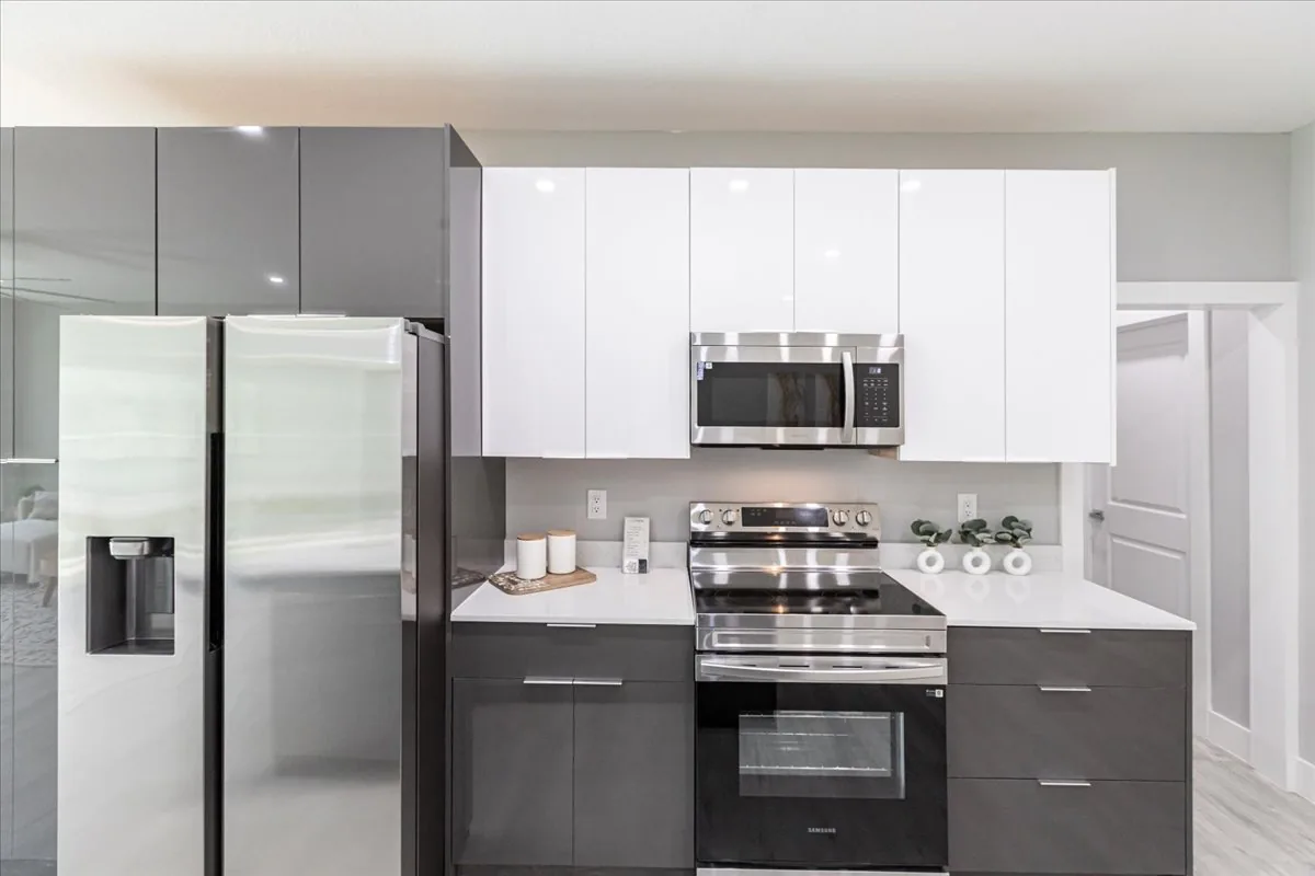 CyberHouse 7 kitchen — quartz island, dark cabinetry and stainless appliances