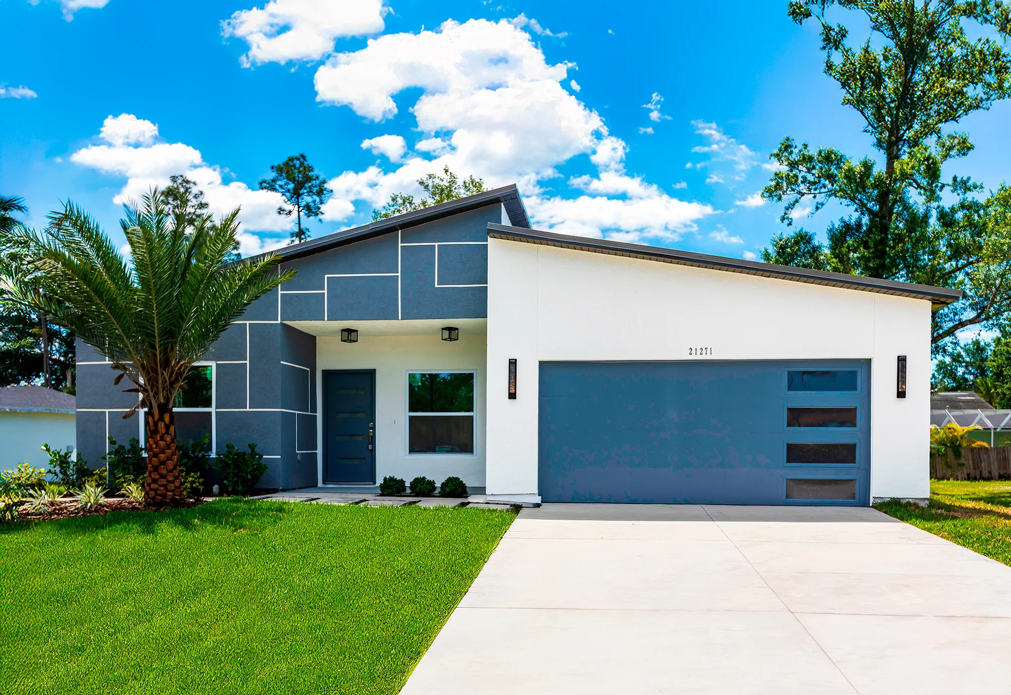 A completed CyberHouse 7 — a steel-framed single-story home with a single-slope roof — photographed from the street